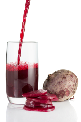 Beet root and beet juice pouring into glass