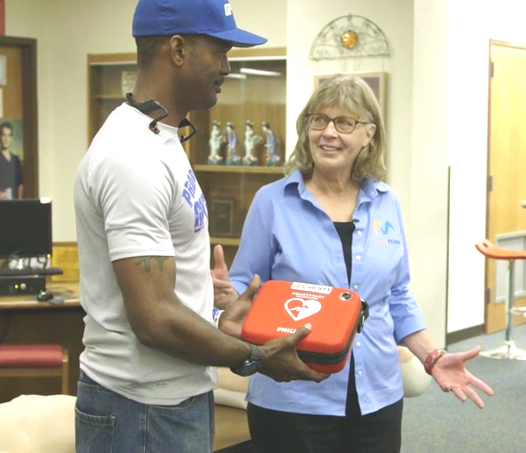 Brooke de Lench donating AED to Ira Carter, President of Grand Prairie TX youth football 