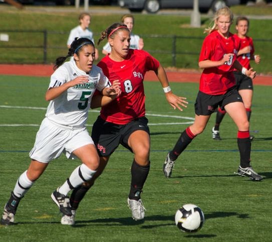 Women's soccer players vying for ball