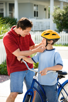 Dad helping son with bike helmet