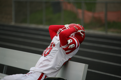 Football player holding head in pain