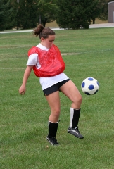 Female soccer player bouncing ball off her knee