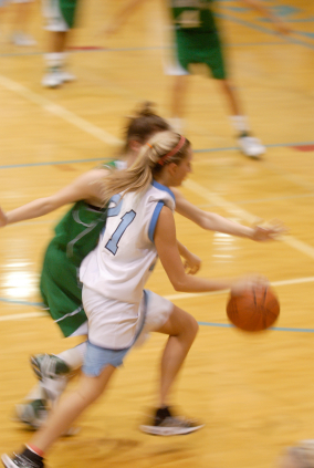 Girls basketball player dribbling up court
