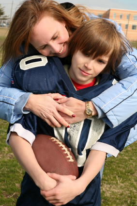 Football mom holding her son