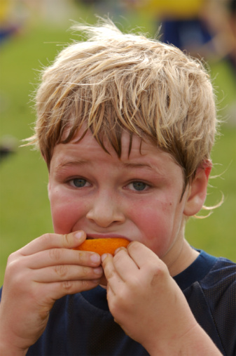 Boy eating orange