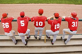 Baseball players at dugout rail