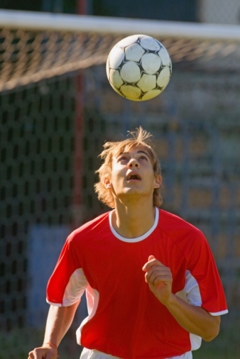 Player bouncing soccer ball on head