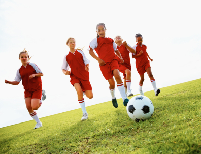 Girl soccer players chasing ball