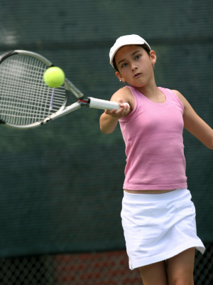 Teenage tennis player hitting ball