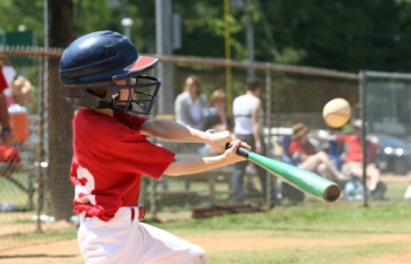 Youth basebll player hitting the ball