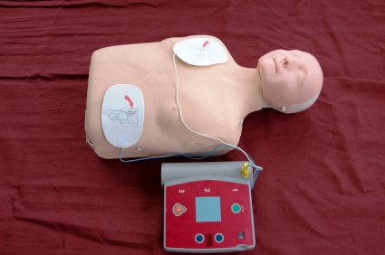 Dummy and AED with pads placed on chest