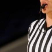 Female basketball official blows whistle