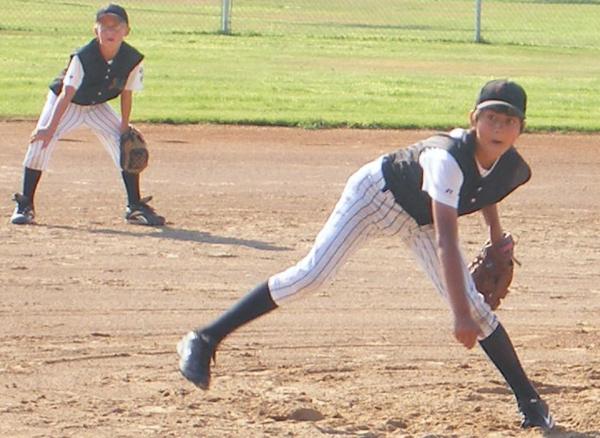 Youth baseball pitcher delivers to the plate