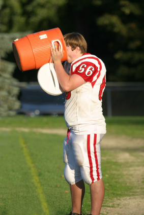 Football player drinking from water cooler