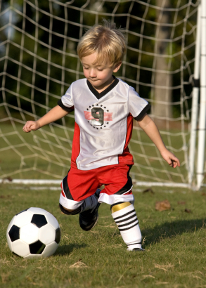 Little boy kicking soccer ball