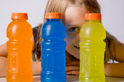 Girl with three bottles of different flavored sports drinks